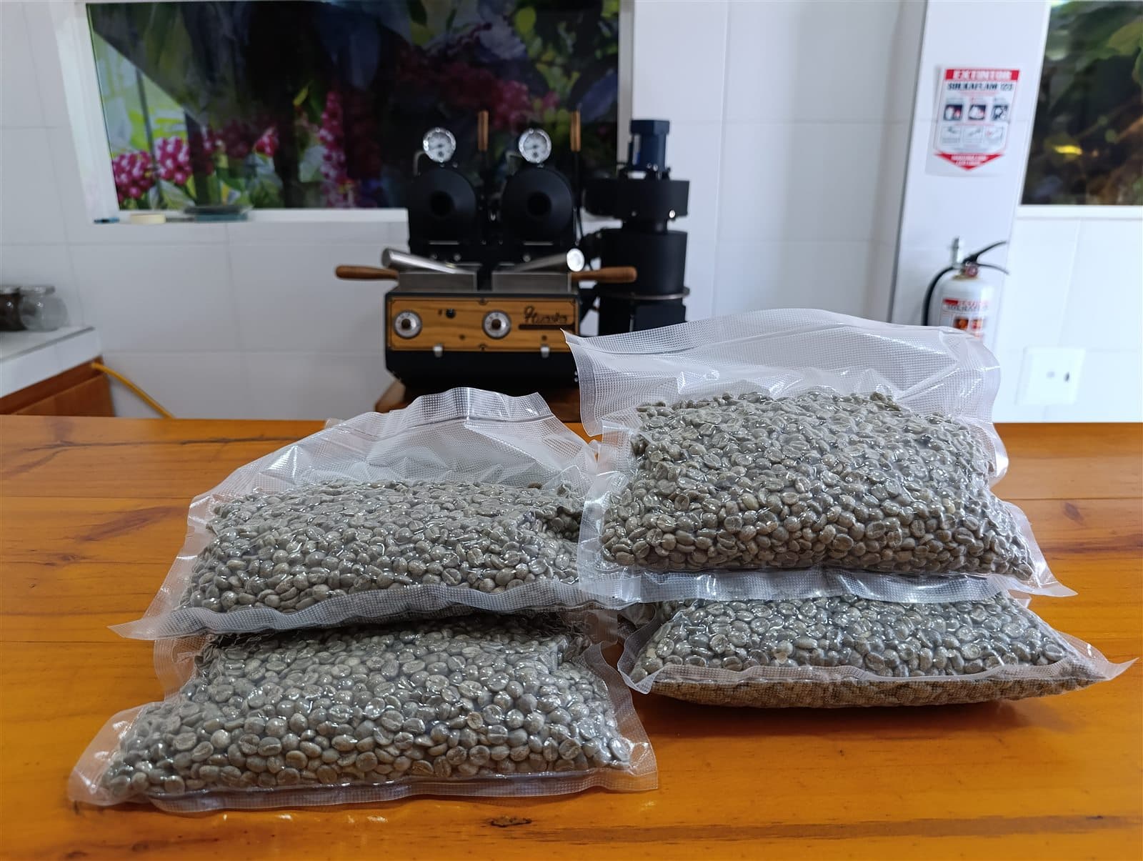 Bolsas de café verde de ValenTo Coffee empacadas al vacío junto al tostador de muestra