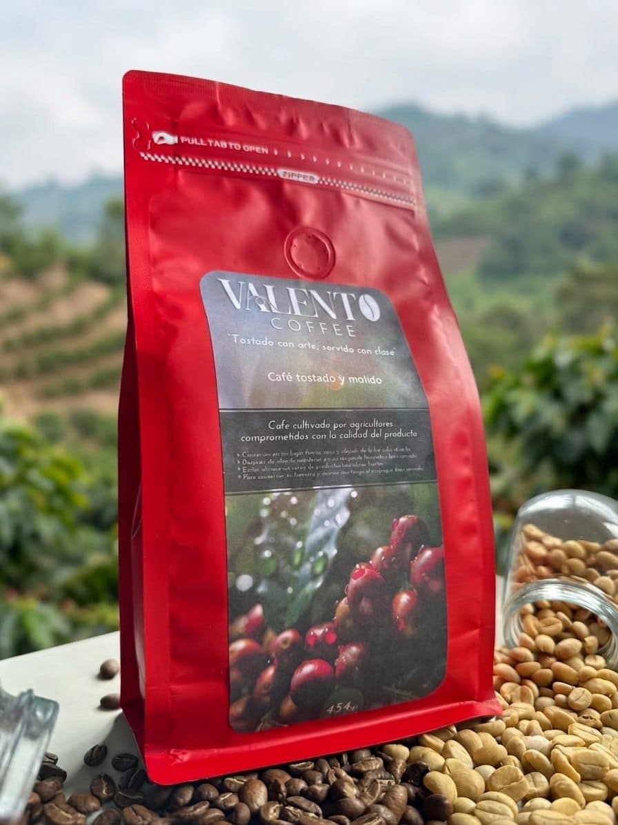 Bolsa roja de café ValenTo Coffee tostado y molido con el cafetal del Huila de fondo