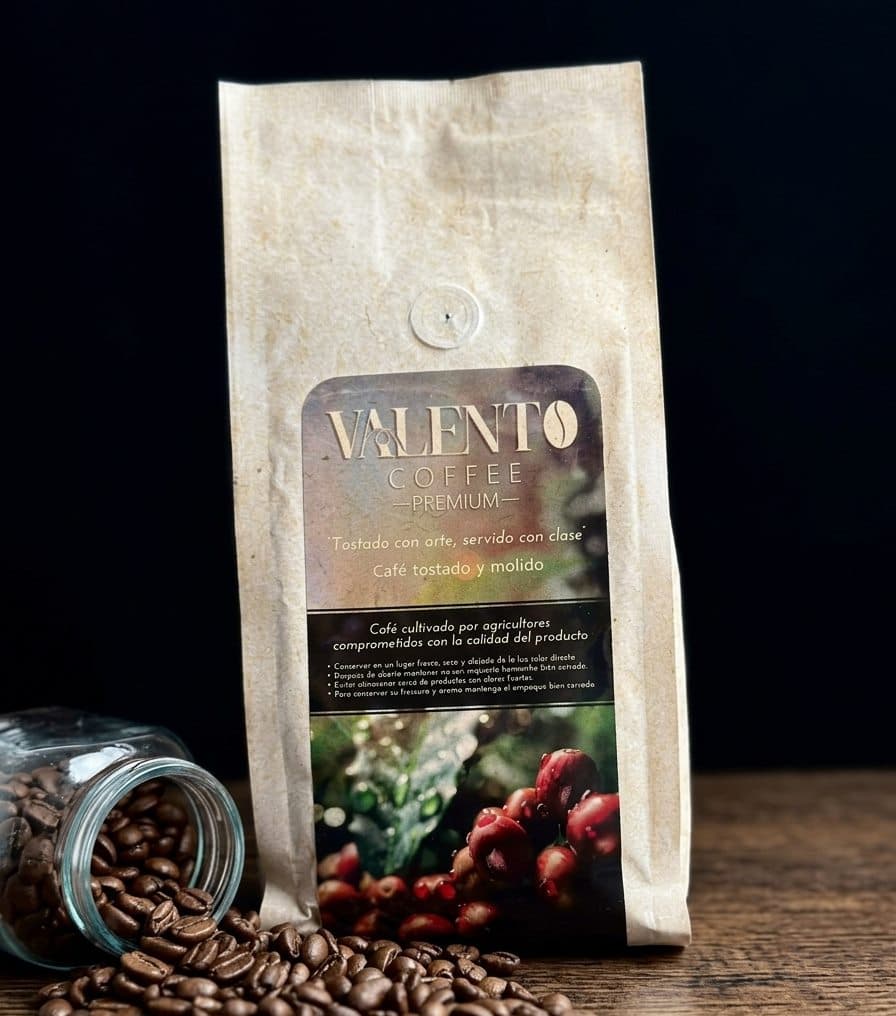 Bolsa de café ValenTo Coffee Premium en grano sobre fondo negro con granos de café tostado
